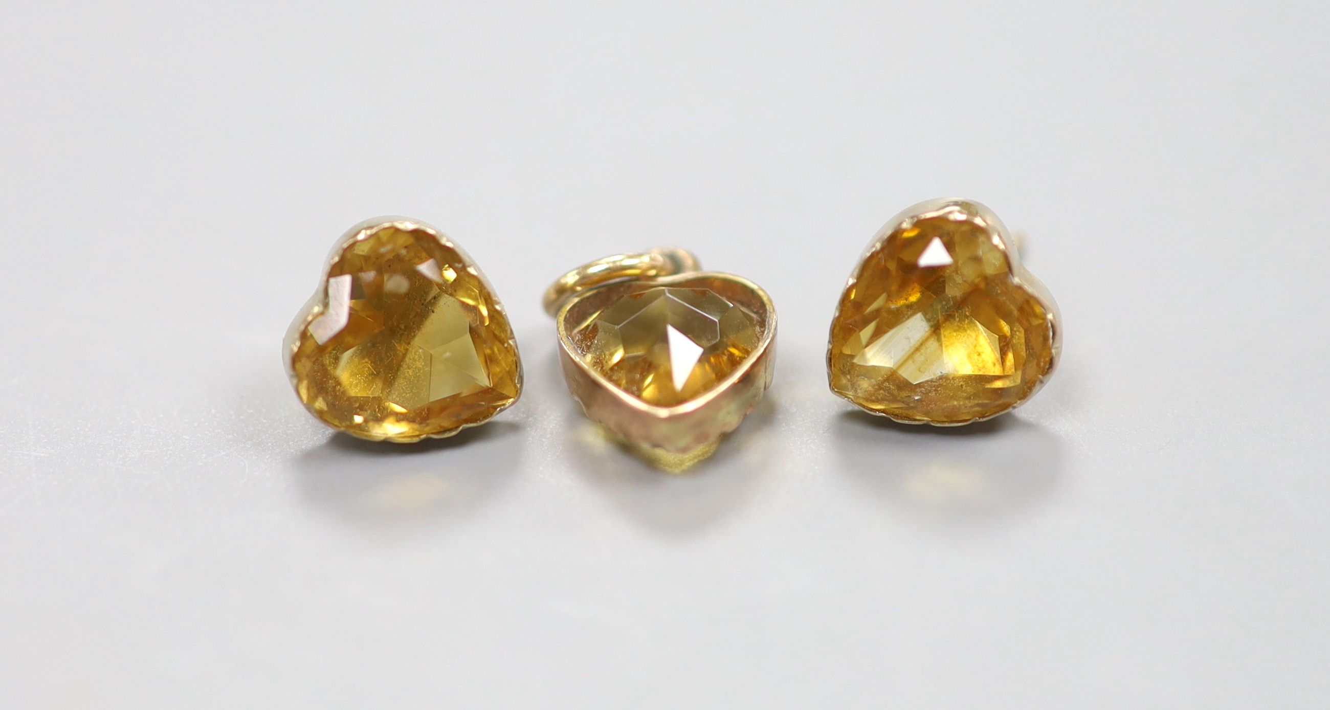 A yellow metal and heart shape citrine pendant, 10mm and pair of matching ear studs(no butterflies), gross 3.6 grams.